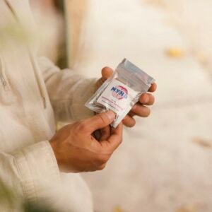 Mynd mushroom capsules in a packet held by a young man's hands